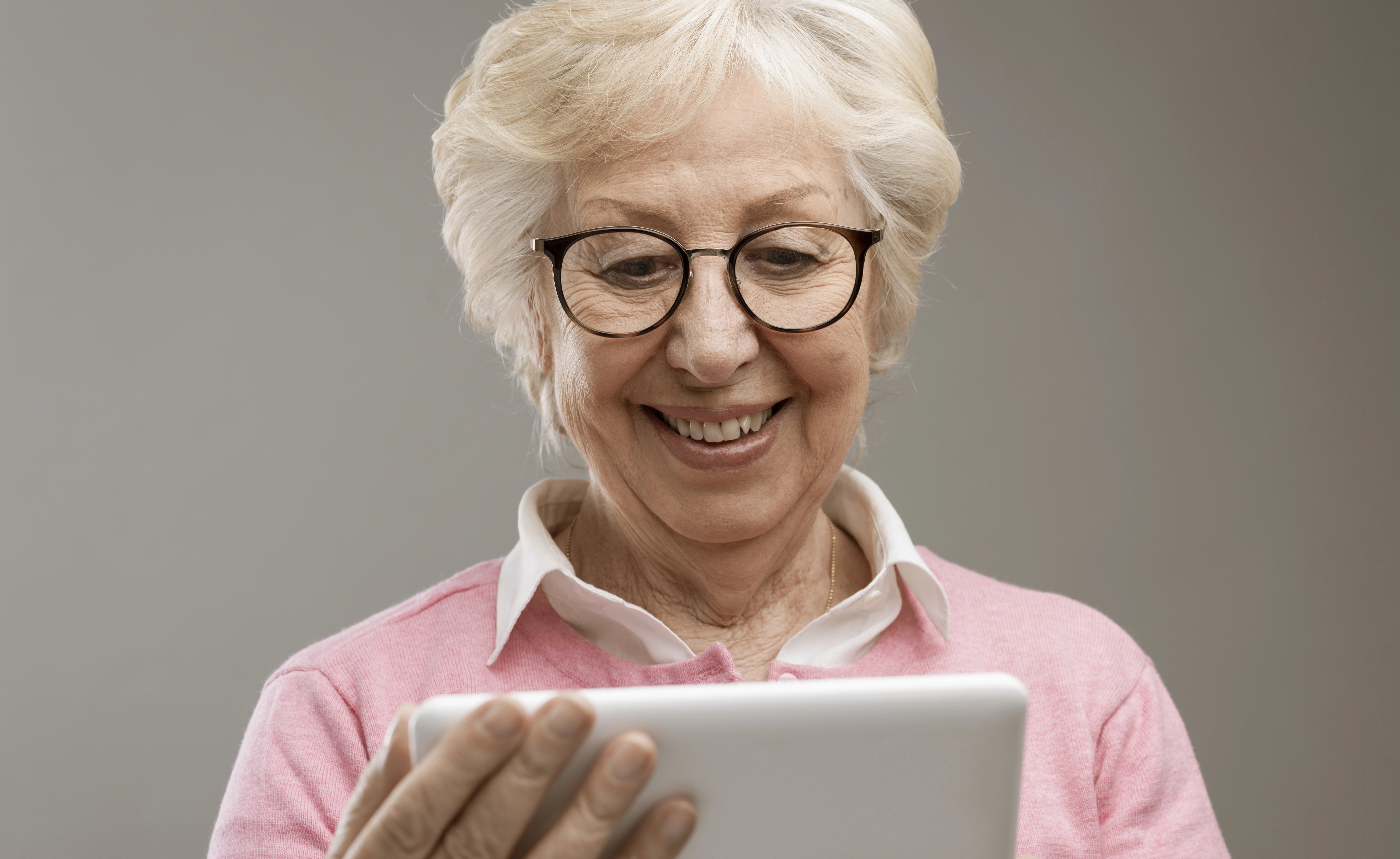 Smiling senior woman looking at tablet